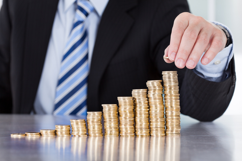 Close-up Of Businessman Hand Put Coins To Stack Of Coins